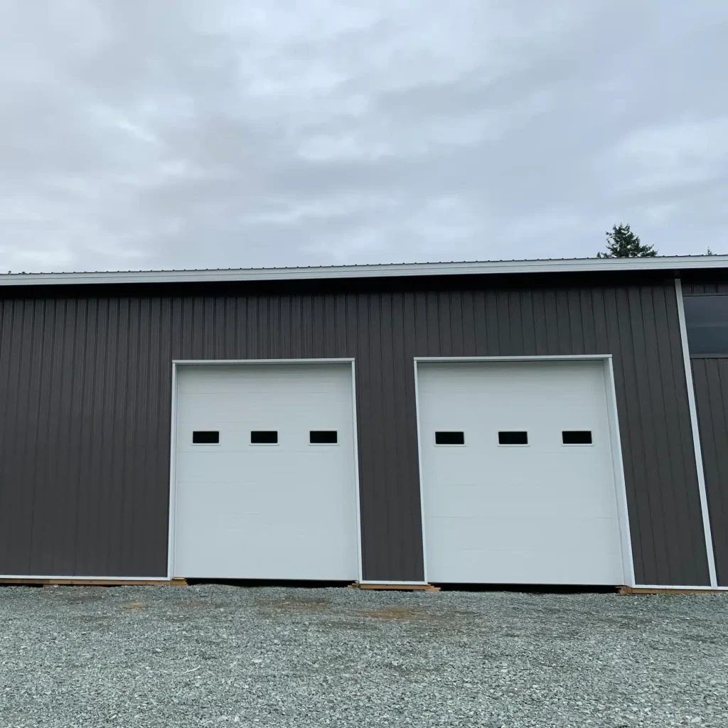 A charcoal post-frame equestrian riding arena