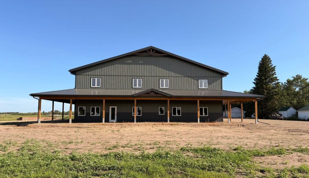 A dark sage post-frame residential shouse