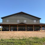 A dark sage post-frame residential shouse