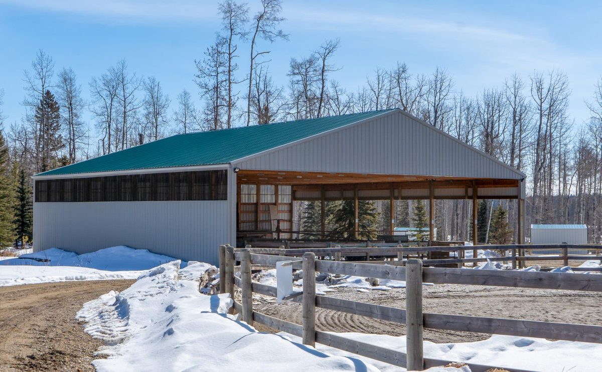 A melchers green post-frame equestrian riding arena with one open side