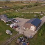 A charcoal post-frame agriculture shop with findoors