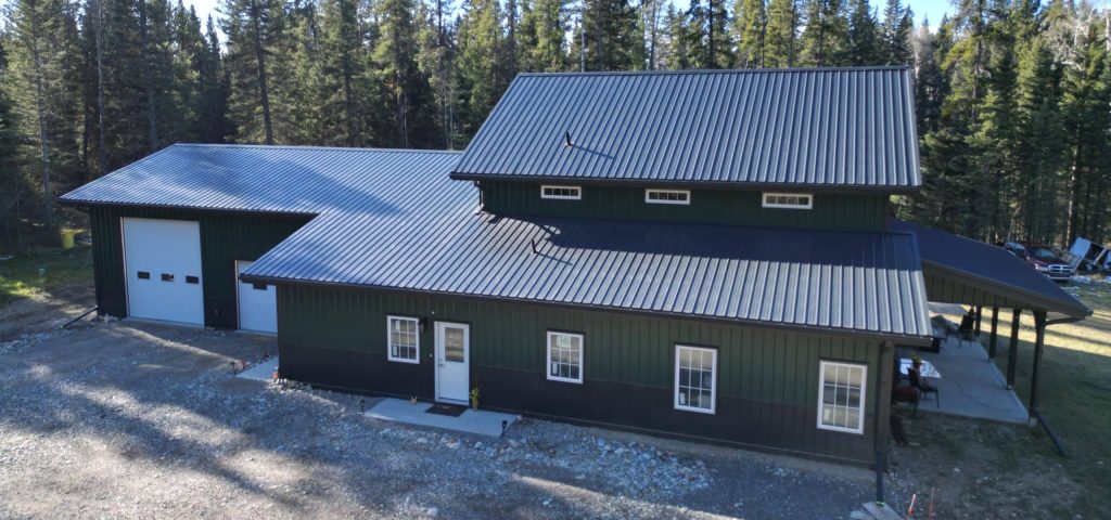 A post-frame melchers green residential barndominium with an attached garage