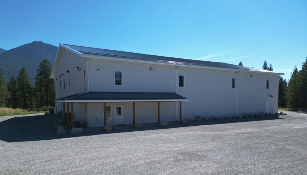 A white white post-frame commercial gymnastics studio with soffits