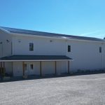 A white white post-frame commercial gymnastics studio with soffits