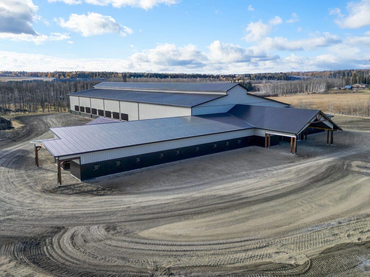 A stone grey post-frame equestrian riding Arena