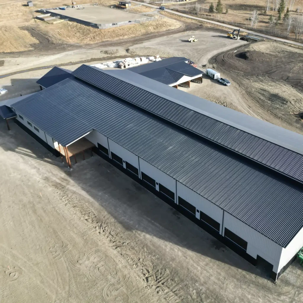 A stone grey post-frame equestrian riding Arena