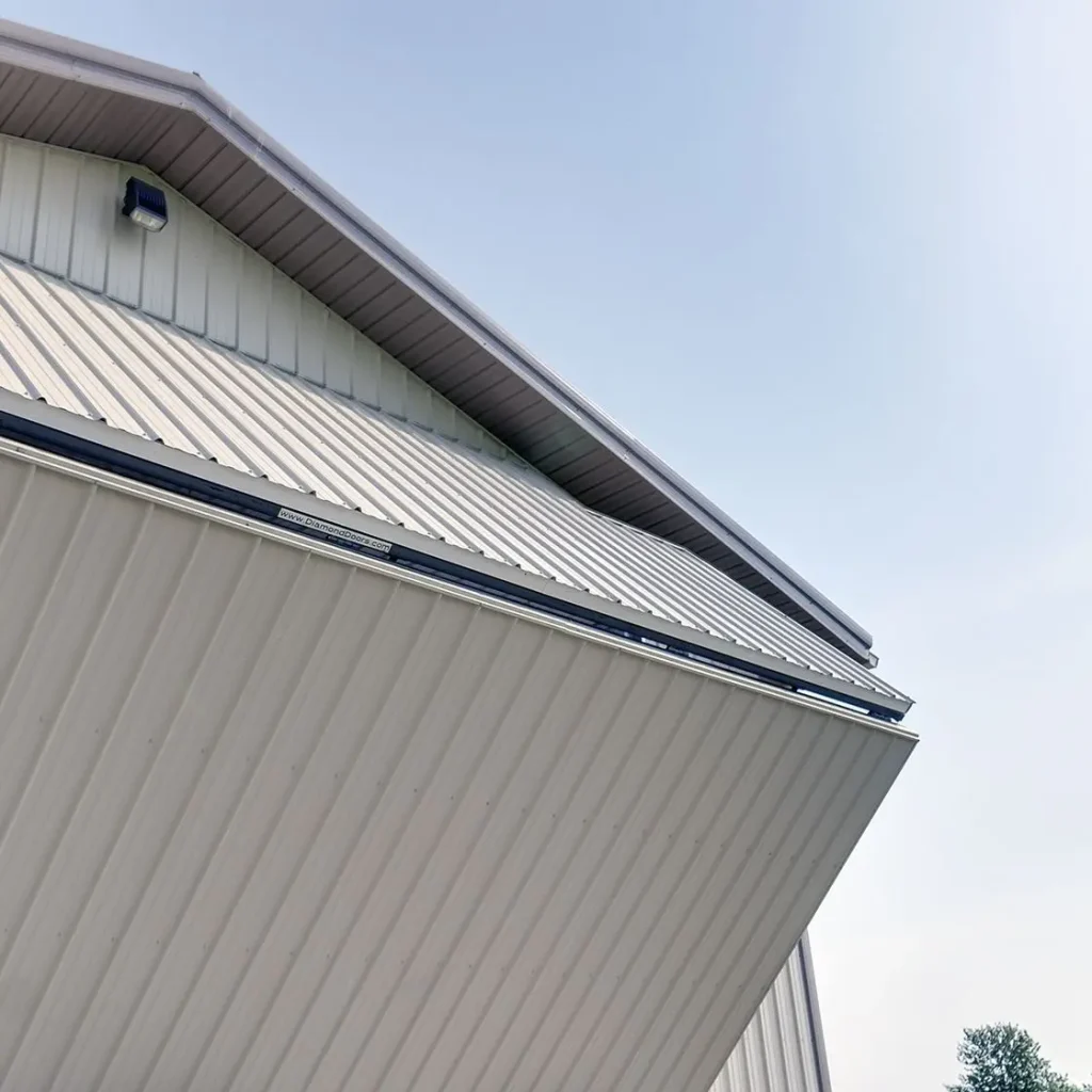 A light stone post-frame lifestyle & hobby shop with a bi-fold door and dark brown roof