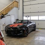 A black post-frame lifestyle & hobby shop with soffits and a overhead door