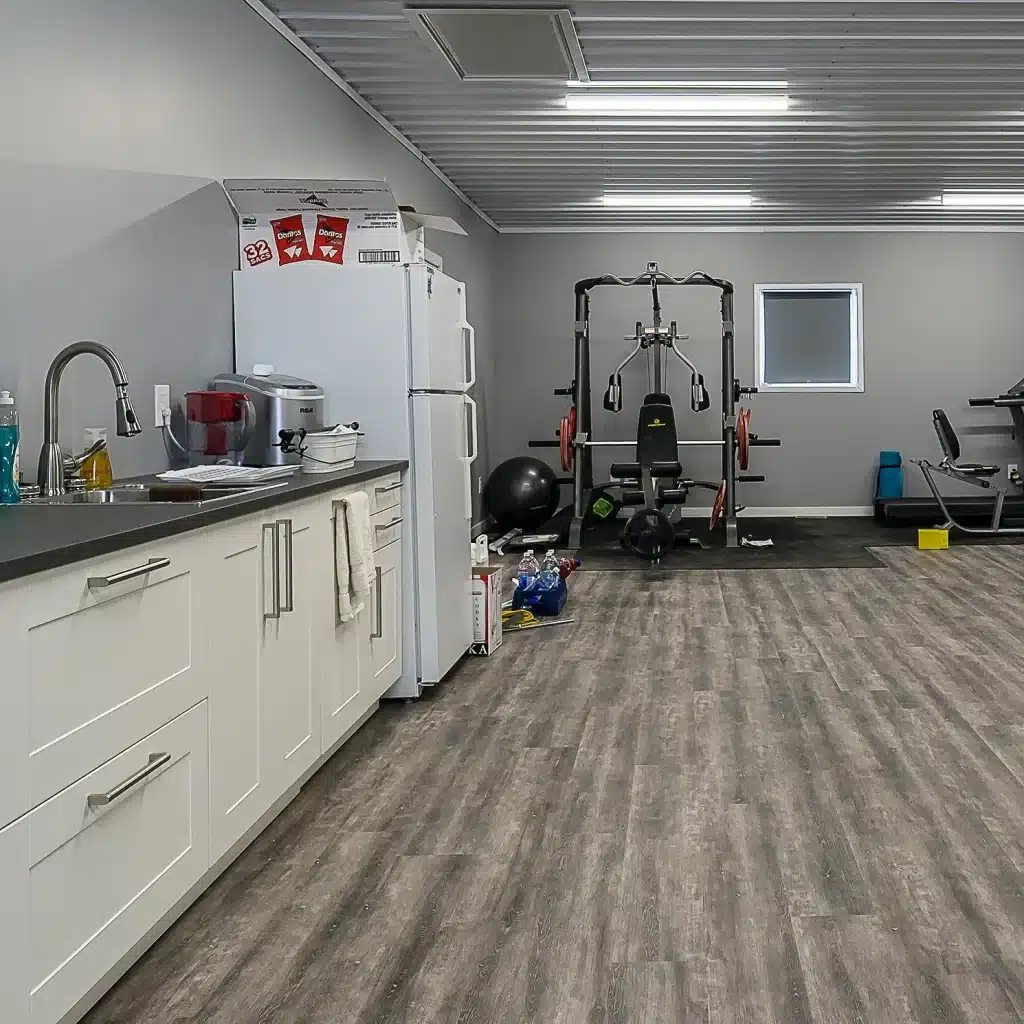 A black post-frame lifestyle & hobby shop with soffits and a overhead door