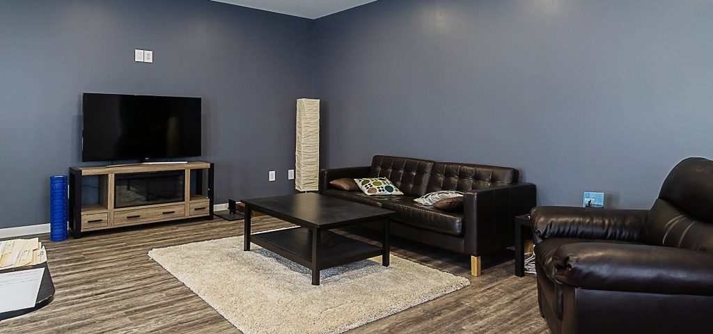 A black post-frame lifestyle & hobby shop with soffits and a overhead door