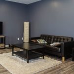 A black post-frame lifestyle & hobby shop with soffits and a overhead door