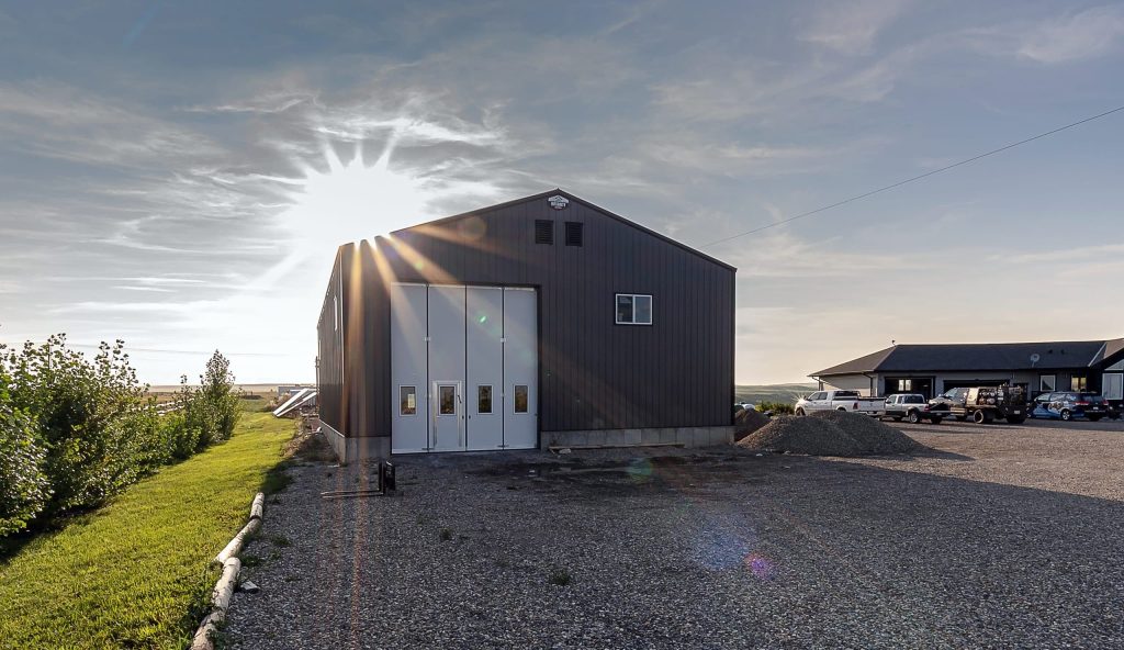 A charcoal post-frame agriculture shop with findoors