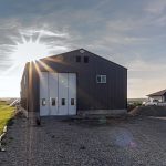 A charcoal post-frame agriculture shop with findoors
