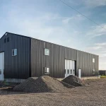 A charcoal post-frame agriculture shop with findoors