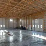 A charcoal post-frame agriculture shop with findoors