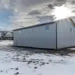 An ascot grey post-frame lifestyle & Hobby shop with an overhead door