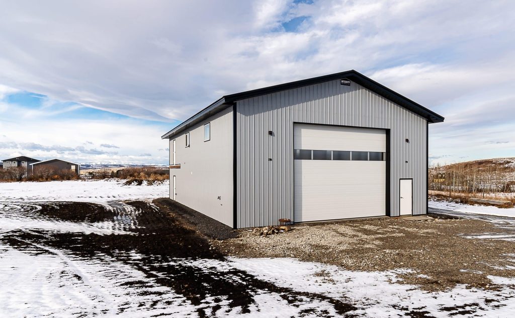 An ascot grey post-frame lifestyle & Hobby shop with an overhead door