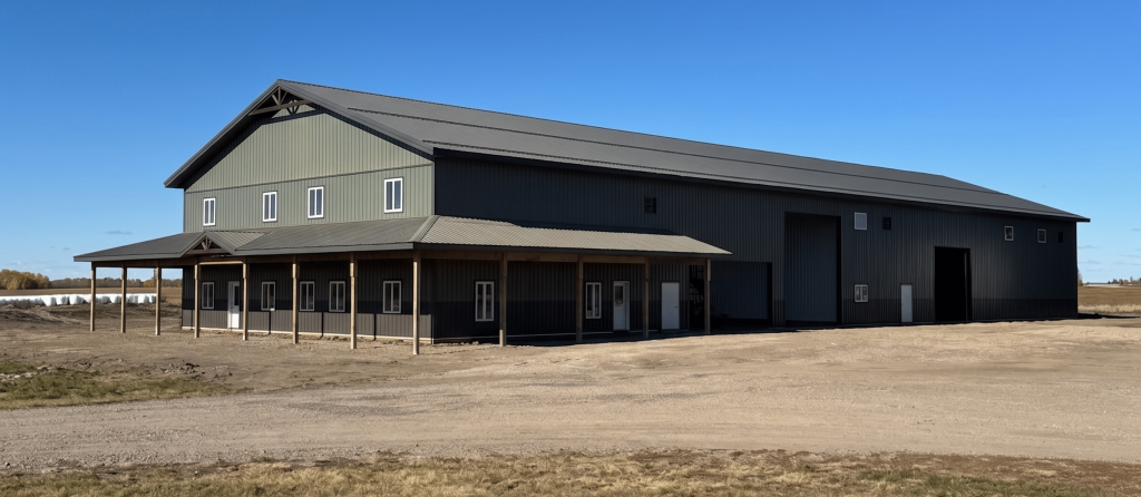 Post-frame residential building - The Shouse in greed metal cladding and a wrap-around porch in Saskatchewan