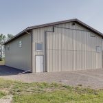 A light stone post-frame lifestyle & hobby shop with a bi-fold door and dark brown roof