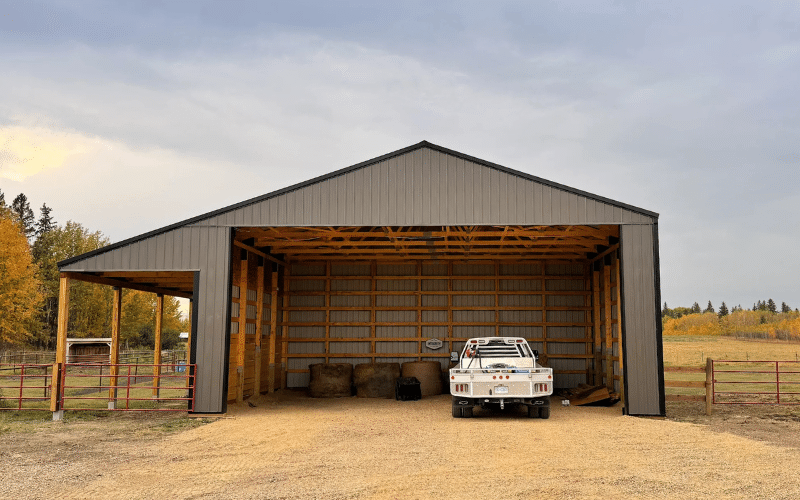 A charcoal post-frame hayshed with one overhead door