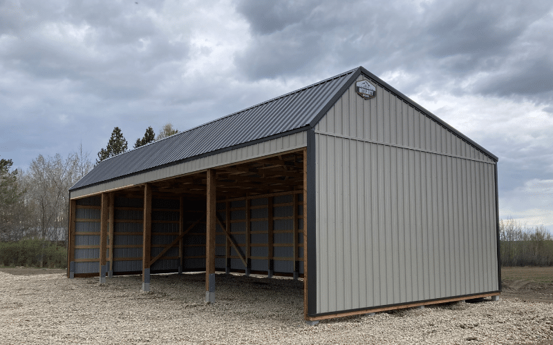 A stone grey post-frame livestock shelter