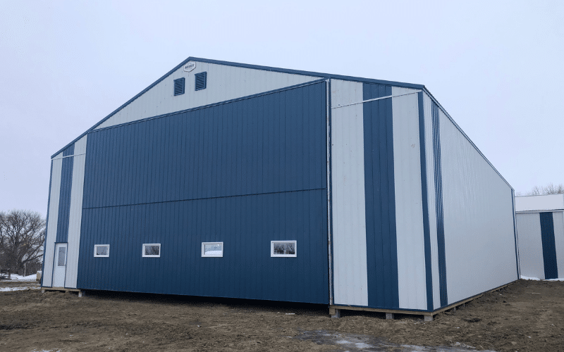 A white white post-frame agricultural shop with bifold doors