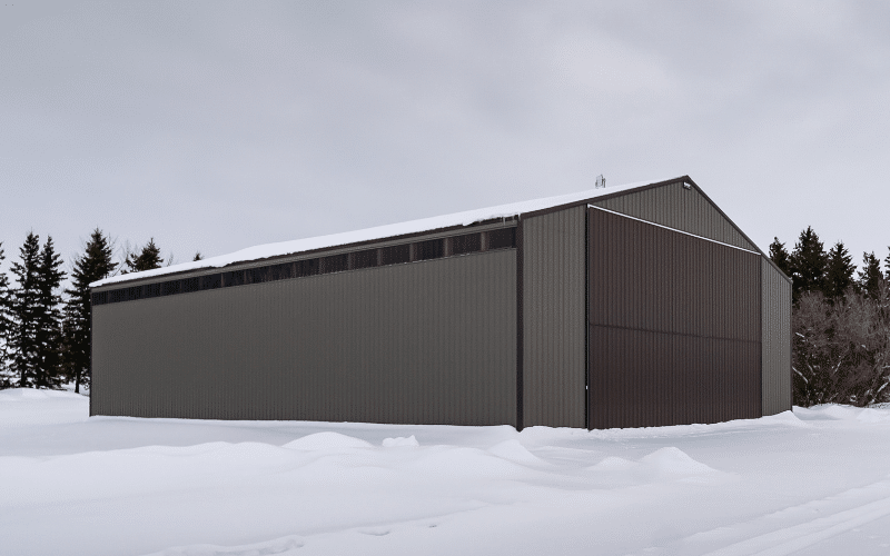 A sable post-frame agricultural machine shed with a bifold door