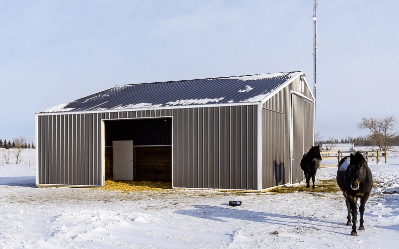 A Charcoal post-frame equestrian barn with sliding doors