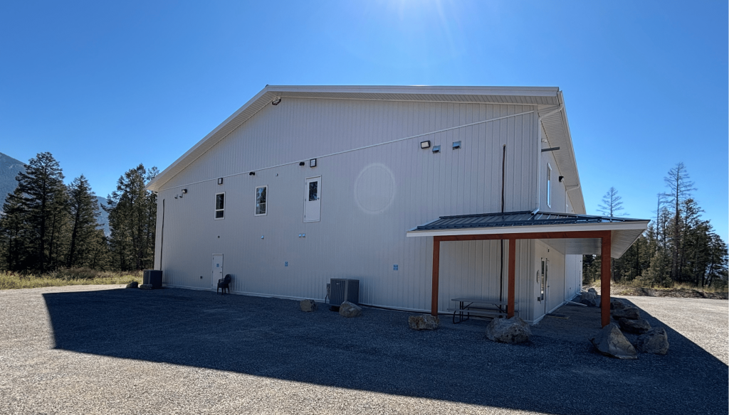 A white white post-frame commercial gymnastics studio with soffits