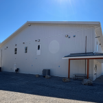 A white white post-frame commercial gymnastics studio with soffits