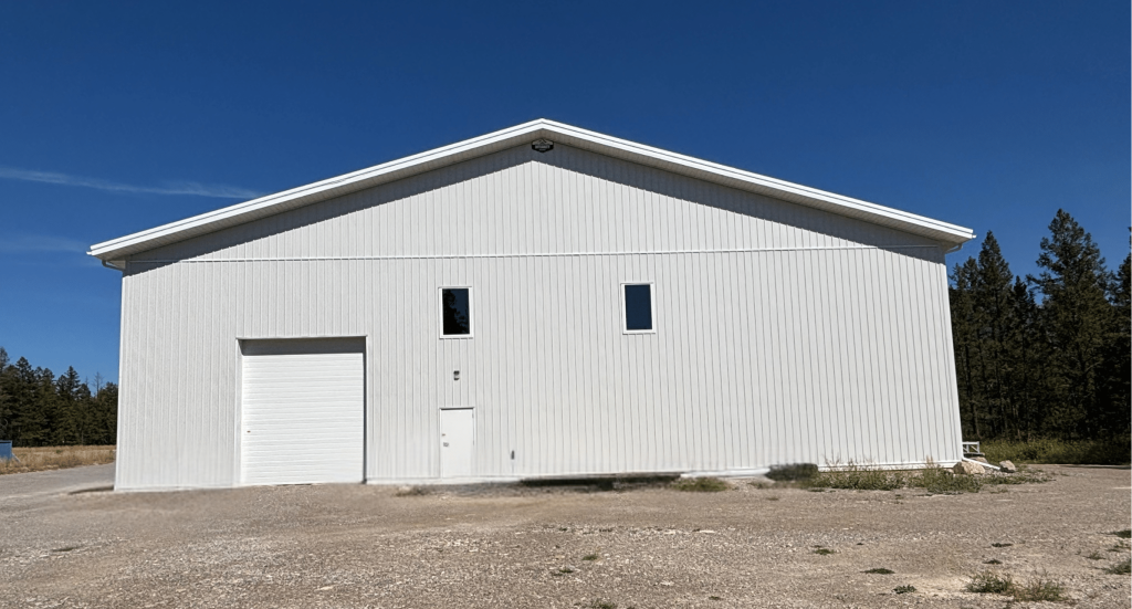 A white white post-frame commercial gymnastics studio with soffits