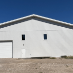 A white white post-frame commercial gymnastics studio with soffits