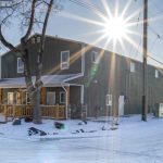A dark sage commercial shop with a front porch and open lean-to