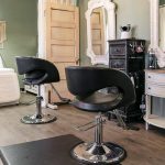 A dark sage commercial shop with a front porch and open lean-to