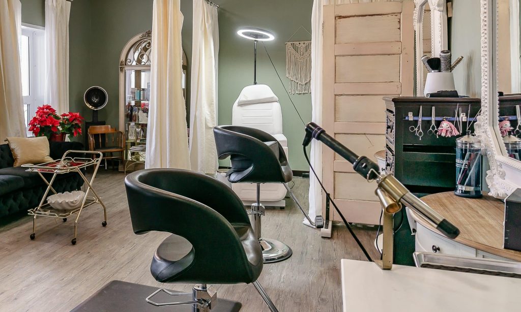 A dark sage commercial shop with a front porch and open lean-to