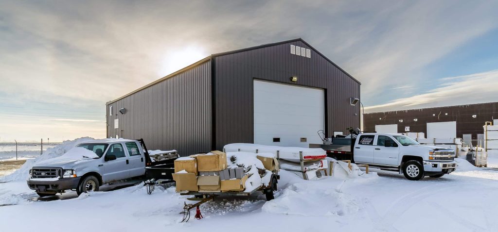 A charcoal post-frame commercial shop with an overhead door