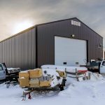 A charcoal post-frame commercial shop with an overhead door