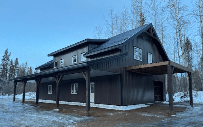 A black residential post frame- carriage house XL with timber accents, and open lean-tos