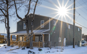 A dark sage commercial shop with a front porch and open lean-to