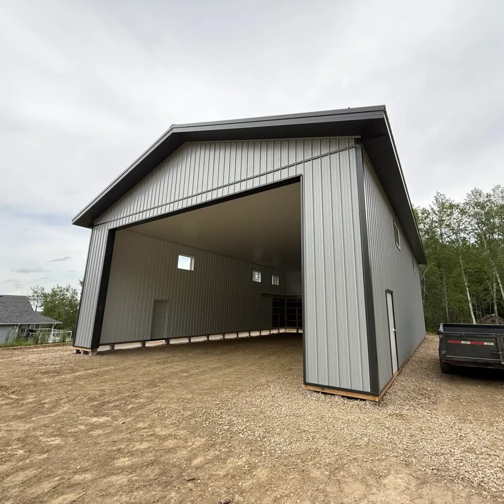 A regent grey post-frame lifestyle & hobby shop with soffits and a overhead door