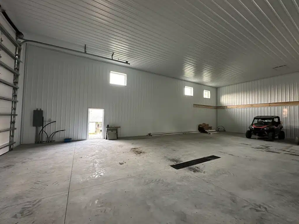 A regent grey post-frame lifestyle & hobby shop with soffits and a overhead door