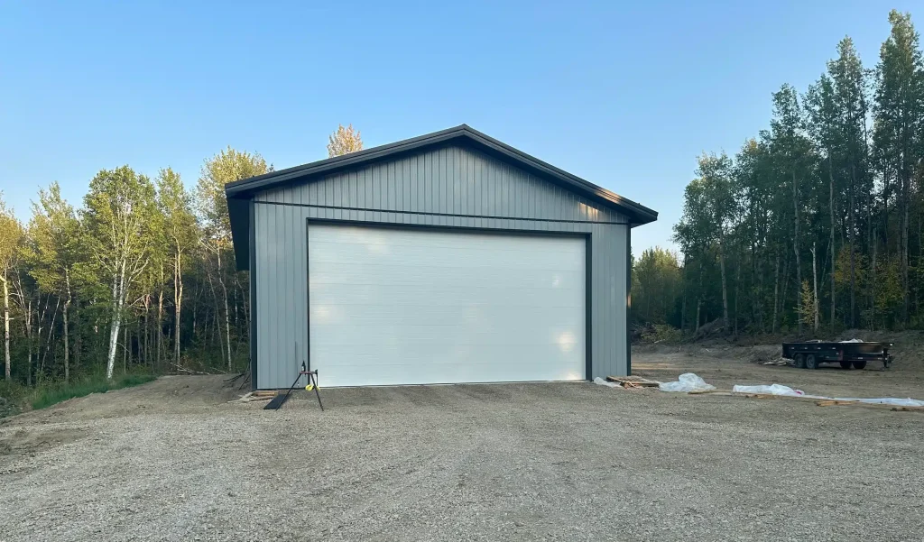 A regent grey post-frame lifestyle & hobby shop with soffits and a overhead door