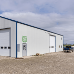 A bone white post-frame commercial shop with heron blue exterior trims