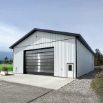 A bright white post-frame Residential Shouse with soffits and an overhead door