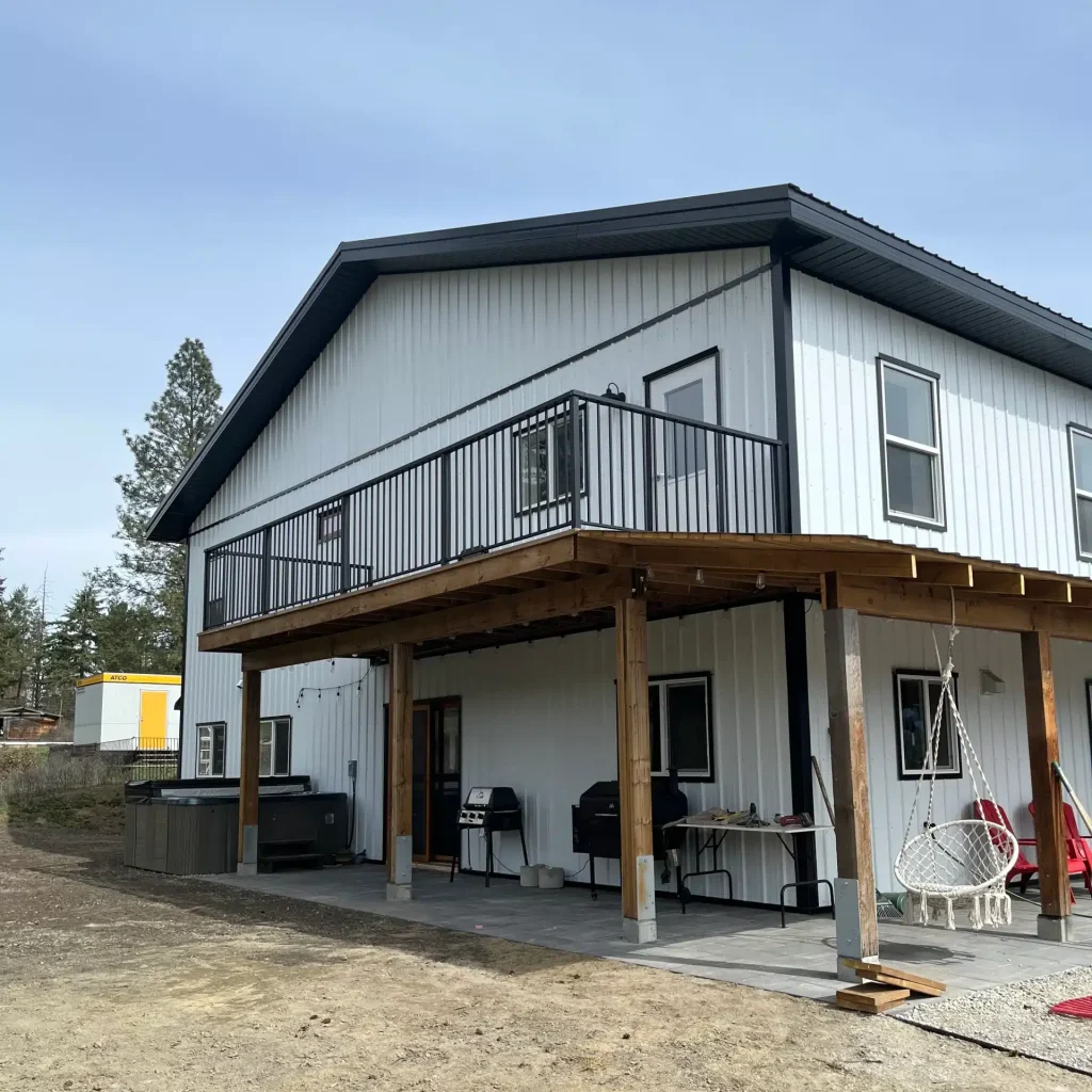 A bright white post-frame Residential Shouse with soffits and an overhead door