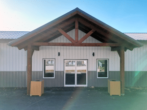 Entrance of Nanton Golf Club post-frame storage building with white liner panel, awning and timber accents