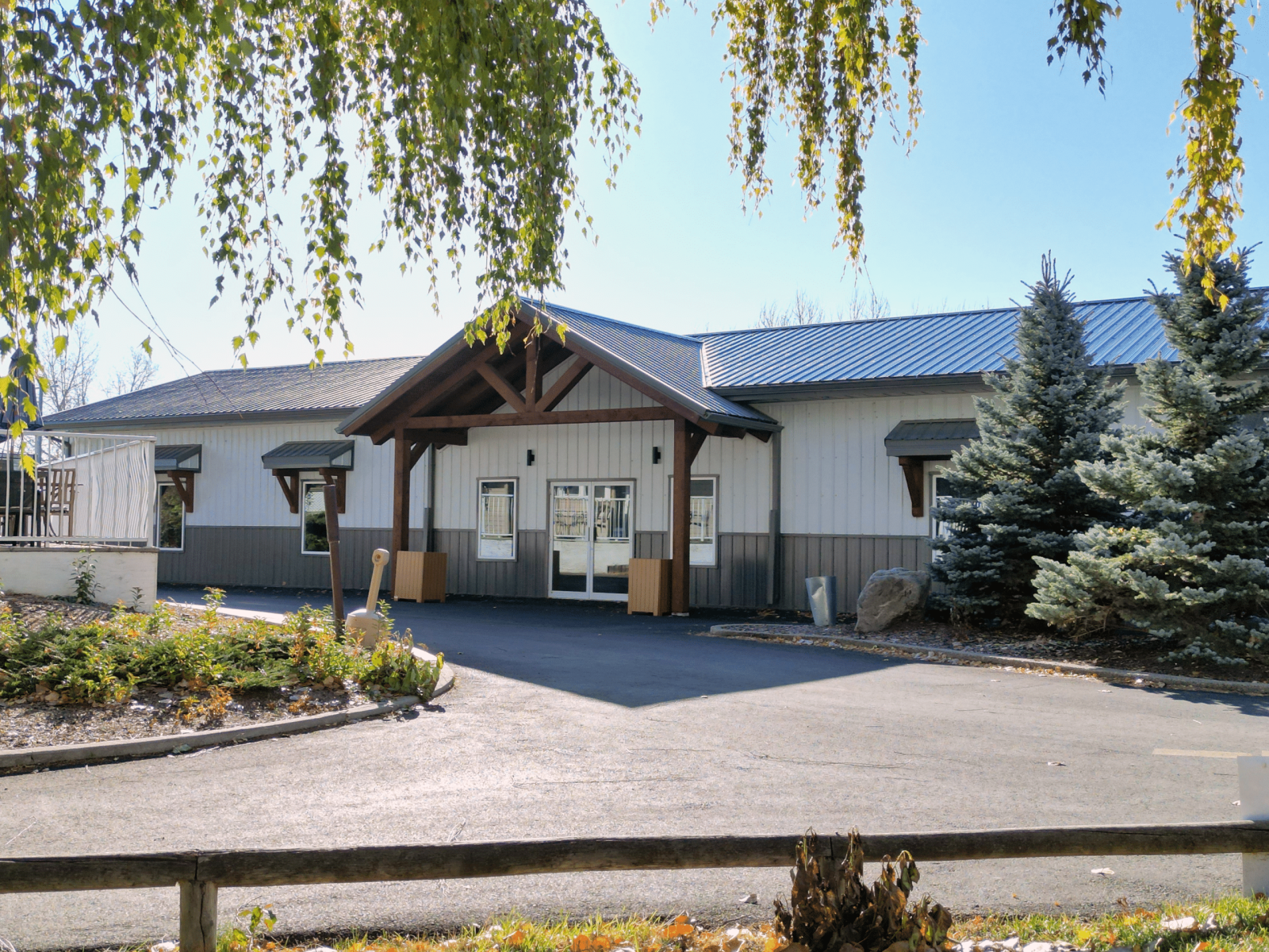 Exterior of Nanton Golf Club post-frame storage building with white liner panel and timber accents