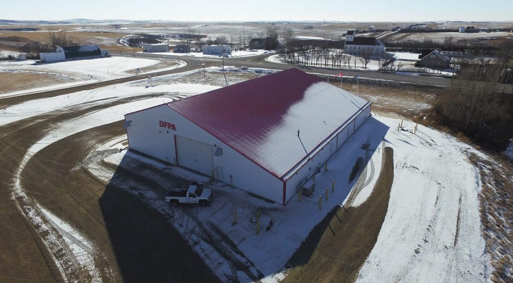 A bright white post-frame commercial building with 10 overhead doors