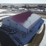 A bright white post-frame commercial building with 10 overhead doors