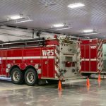 A bright white post-frame commercial building with 10 overhead doors